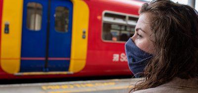 一名女子在火车站戴口罩，以保护自己和他人不感染和传播COVID-19