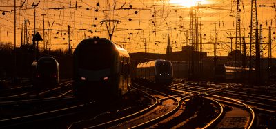 火车在温暖的晚光中抵达多特蒙德车站，弯曲的主线铁轨在阳光下闪闪发光。