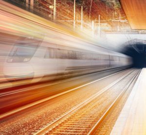 火车穿过隧道的程式化图像，以暖色为特色，表明新的一天的黎明