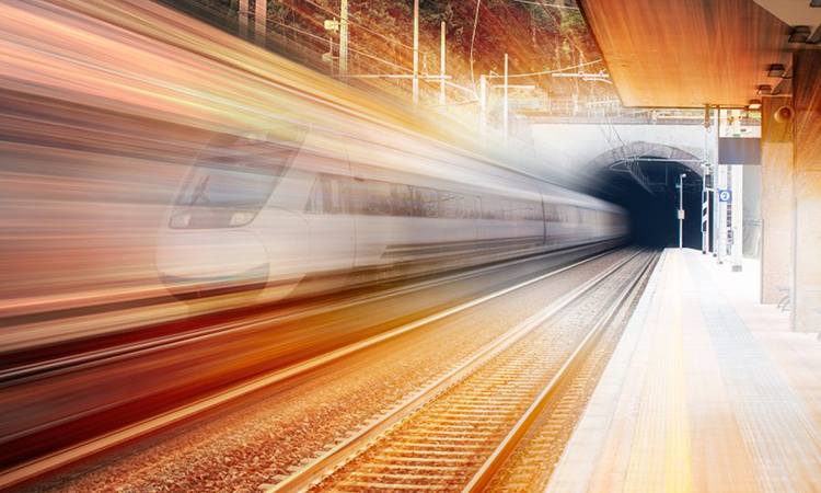 风格化的火车穿过隧道的图像，以暖色为特色，表明新的一天的黎明
