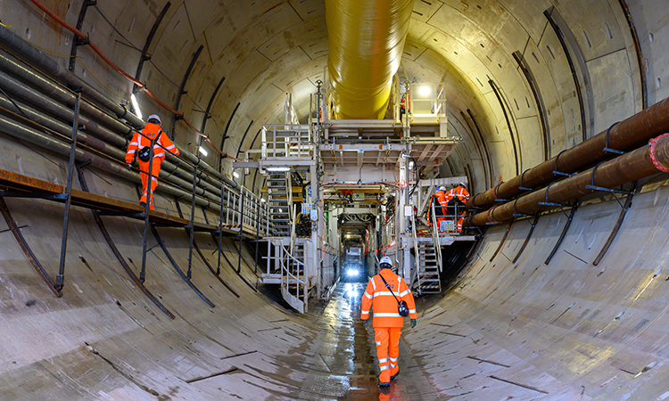 工地工人正走向北入口隧道内的隧道掘进机，