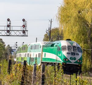 多伦多Metrolinx GO运输动力工业公司634号火车头将一列通勤列车推入郊区的斯特里斯维尔站。