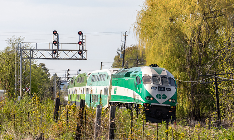 多伦多Metrolinx GO运输动力工业公司634号火车头将一列通勤列车推入郊区的斯特里斯维尔站。