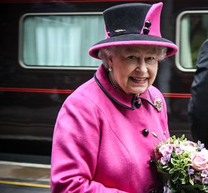 Queen Elizabeth II standing beside a train