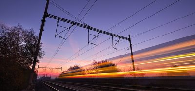 Passenger train on railroad tracks at the sunrise - blurred motion