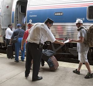 列车员和车站工作人员协助乘客登上美铁列车。