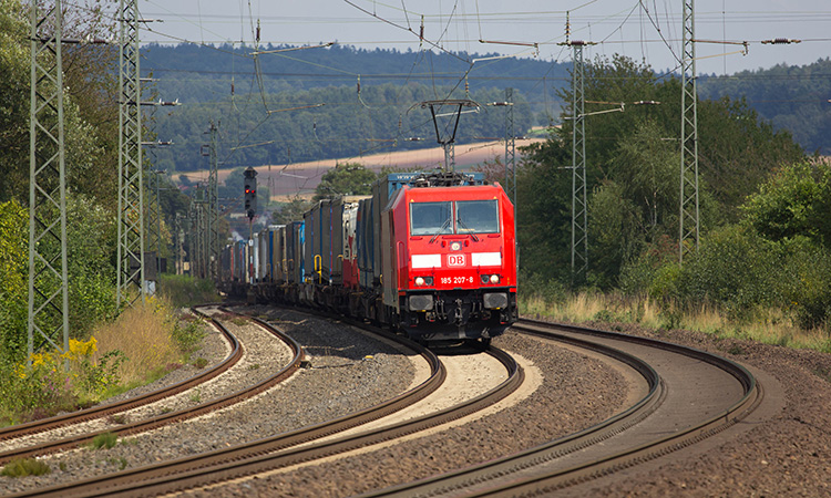 DB (Deutsche Bahn)现代机车与集装箱货车在轨道上行驶。